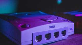 A Sega Dreamcast in moody purple lighting.