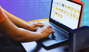 Synology Beestation NAS along with a person using a Windows laptop with the file explorer open