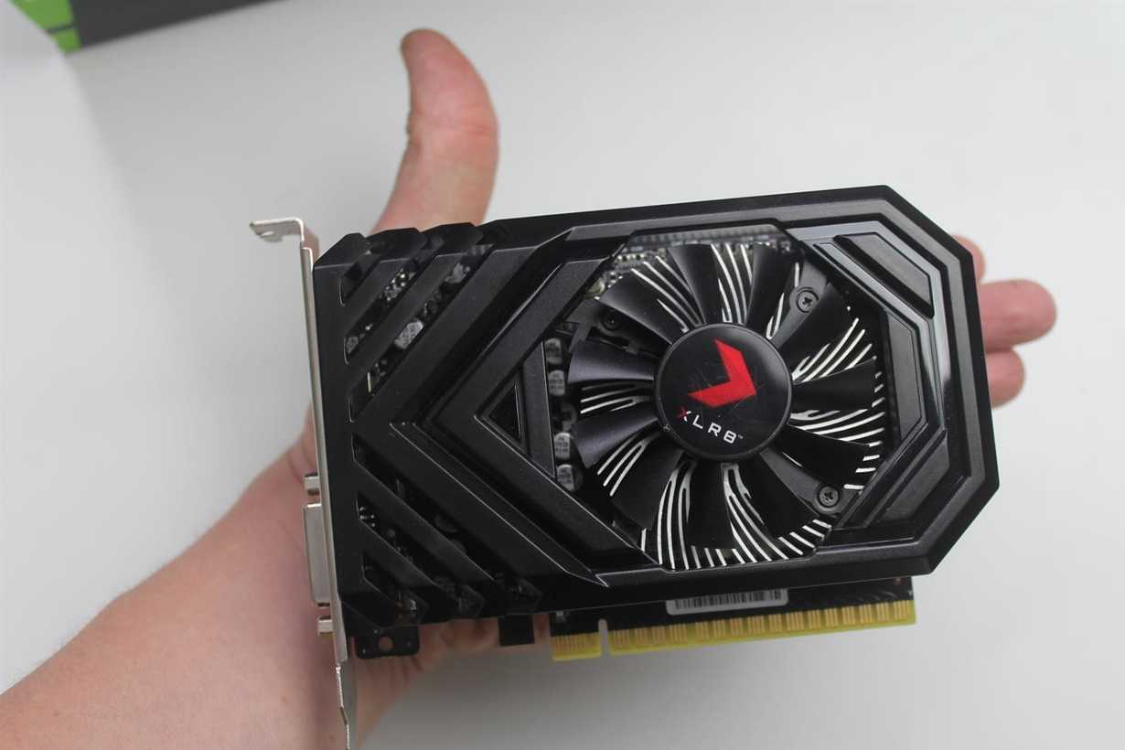 A small black graphics card placed on a person's palm