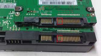 A 2.5-inch hard drive on top of a 3.5-inch hard drive showing SATA power connectors