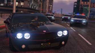 Screenshot from Grand Theft Auto V of three police cars chasing one black car on highway