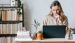 Pensive woman looking at her laptop screen.