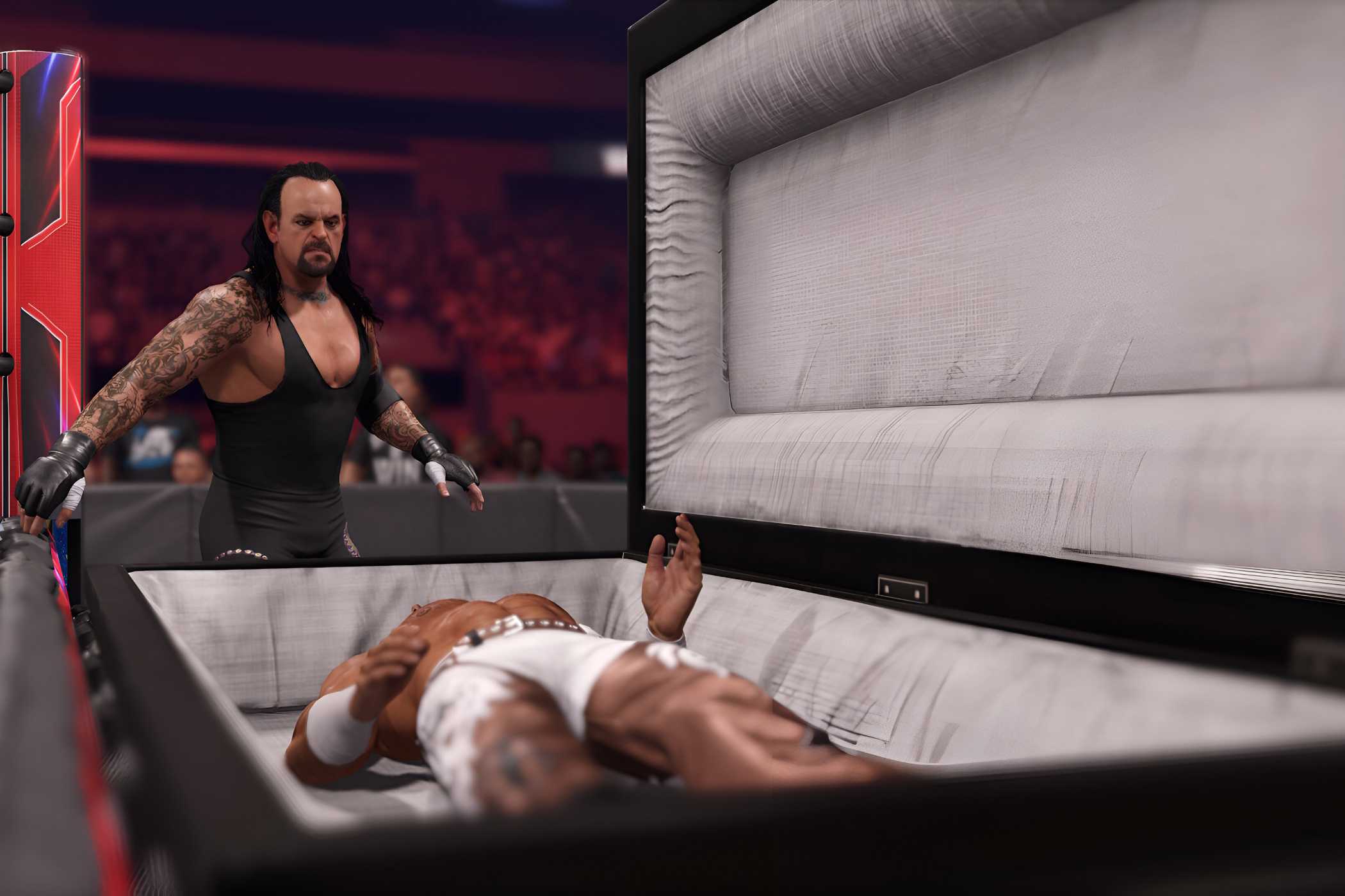 A screenshot from WWE 2K24, showing the Undertaker, wearing a black vest and tights, look over Shawn Michaels who is laying inside a white-lined casket.