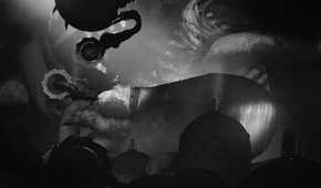 Screenshot from Bionic Bay video game of man walking on metal surface with giant sawblades behind him.