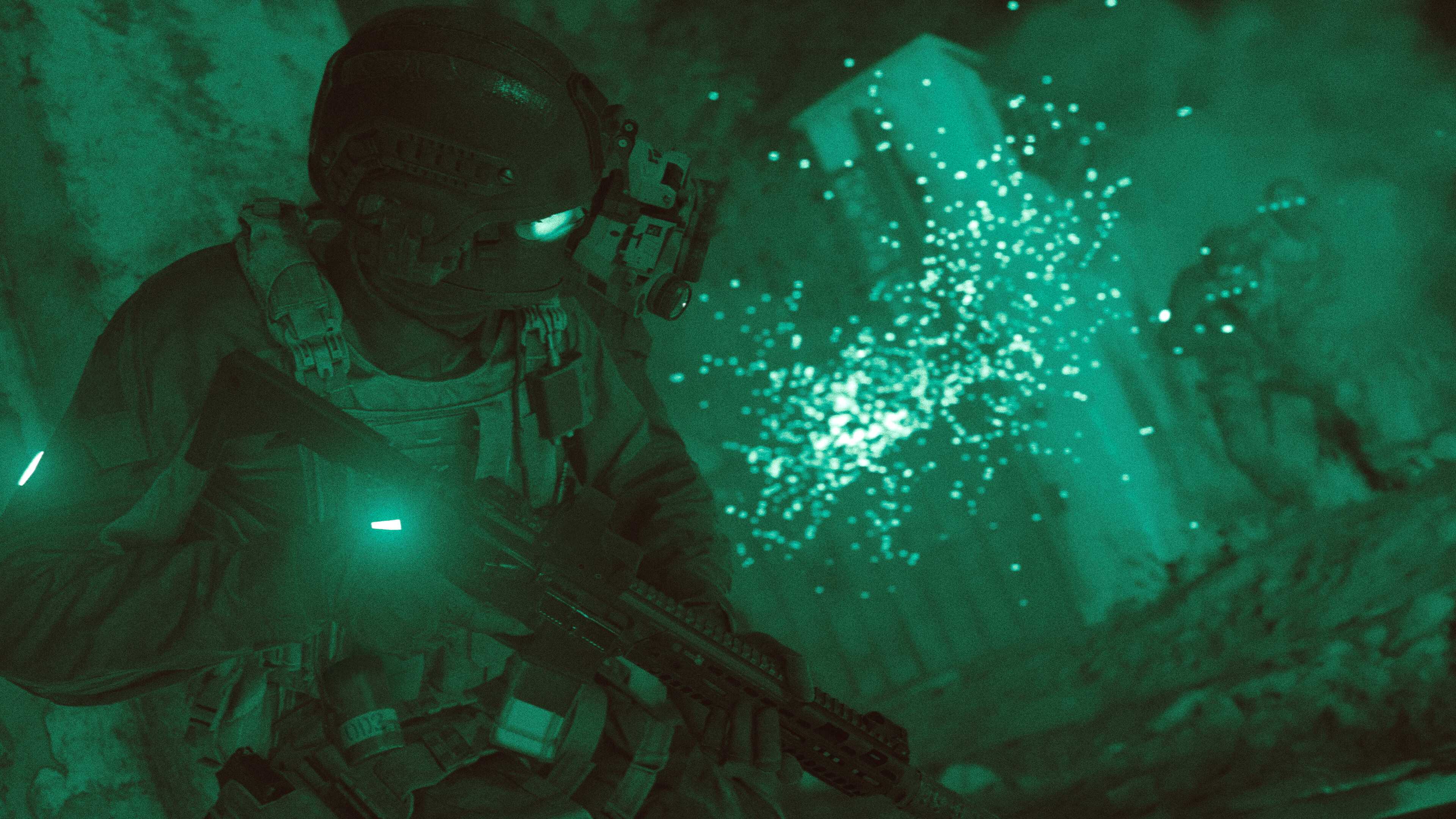 Screenshot from Call of Duty: Modern Warfare (2019) video game of armed soldier in firefight while using night vision goggles