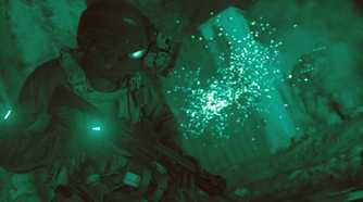 Screenshot from Call of Duty: Modern Warfare (2019) video game of armed soldier in firefight while using night vision goggles