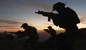 Screenshot from Call of Duty: Modern Warfare (2019) video game of armed soldiers silhouetted against clear sky