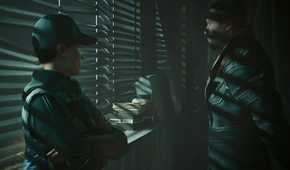 A screenshot from Cyberpunk 2077: Phantom Liberty, showing two characters shrouded in darkness as they stand next to a window.