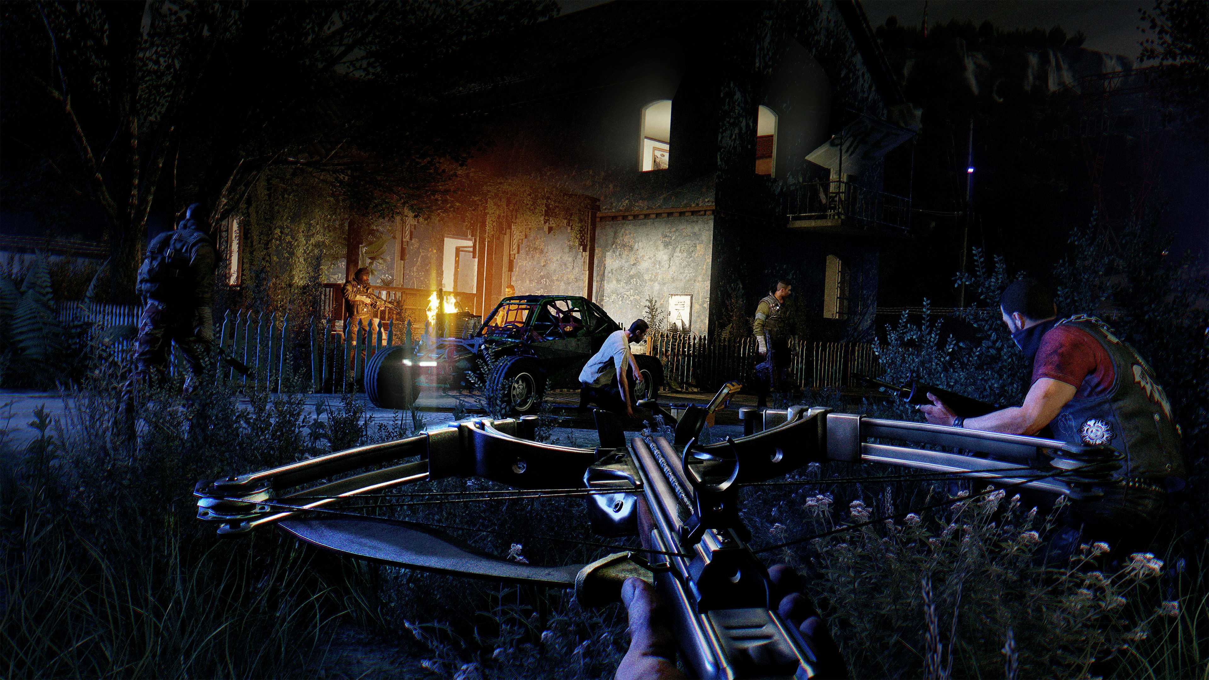 A screenshot from Dying Light: The Following, showing a character holding a crossbow in the night as other characters sneak up on a compound.