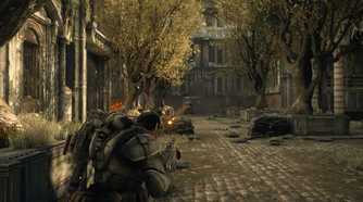A screenshot from the game Gears of War: Ultimate Edition, showing a man in bulky armor standing in a paved garden with trees on either side.