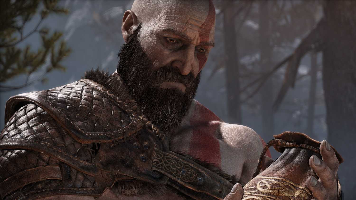 Kratos, a Greek God with white skin, red tattoos and a thick beard, wearily looking at a leather pouch he is holding.