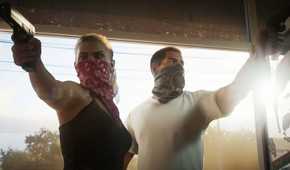 Image from Grand Theft Auto VI video game of a female and male character with masks over their mouths entering a room with pistols drawn.