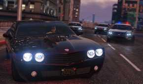 Three police cars chasing Franklin driving a black muscle car