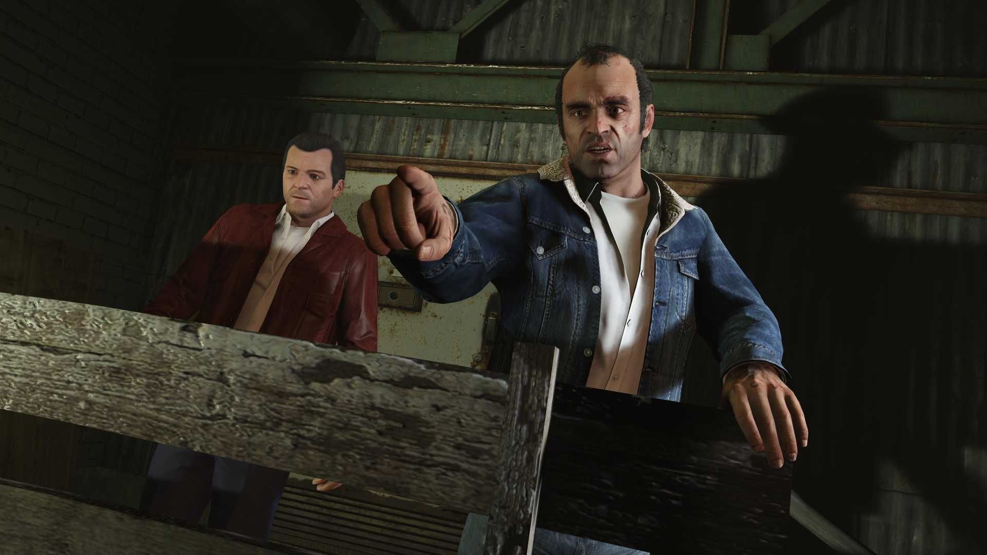 Trevor pointing at the direction of the screen and Michael standing behind him