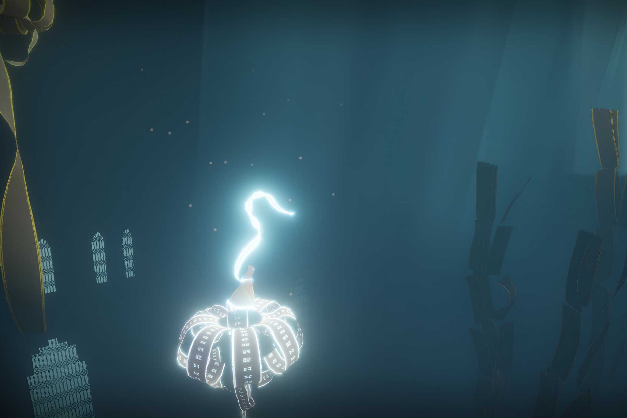 A screenshot from the game Journey, showing the protagonist's robes glow as they float through a dark, blue, environment.