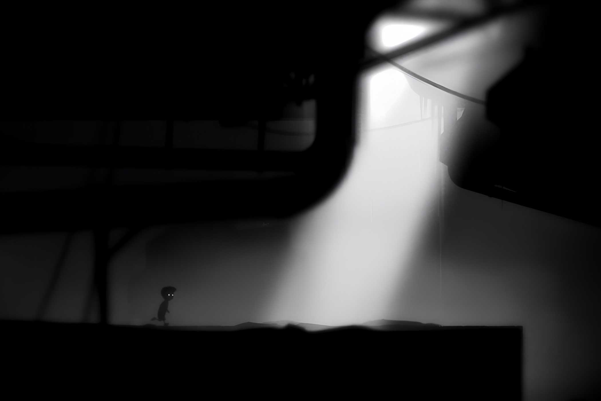 A screenshot from the game Limbo showing sunlight breaking into the dark, eerie, black-and-white environment as the protagonist runs towards it.