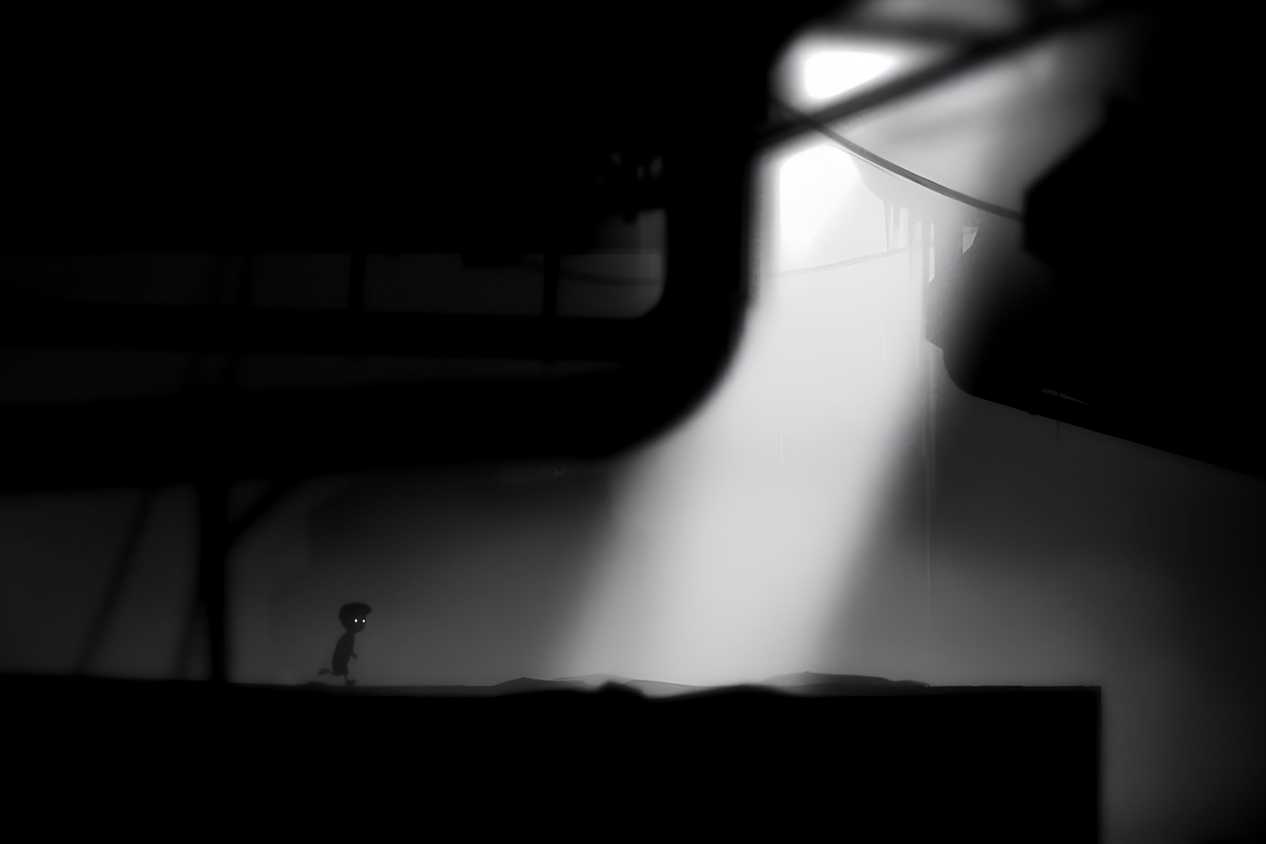 A screenshot from the game Limbo showing sunlight breaking into the dark, eerie, black-and-white environment as the protagonist runs towards it.