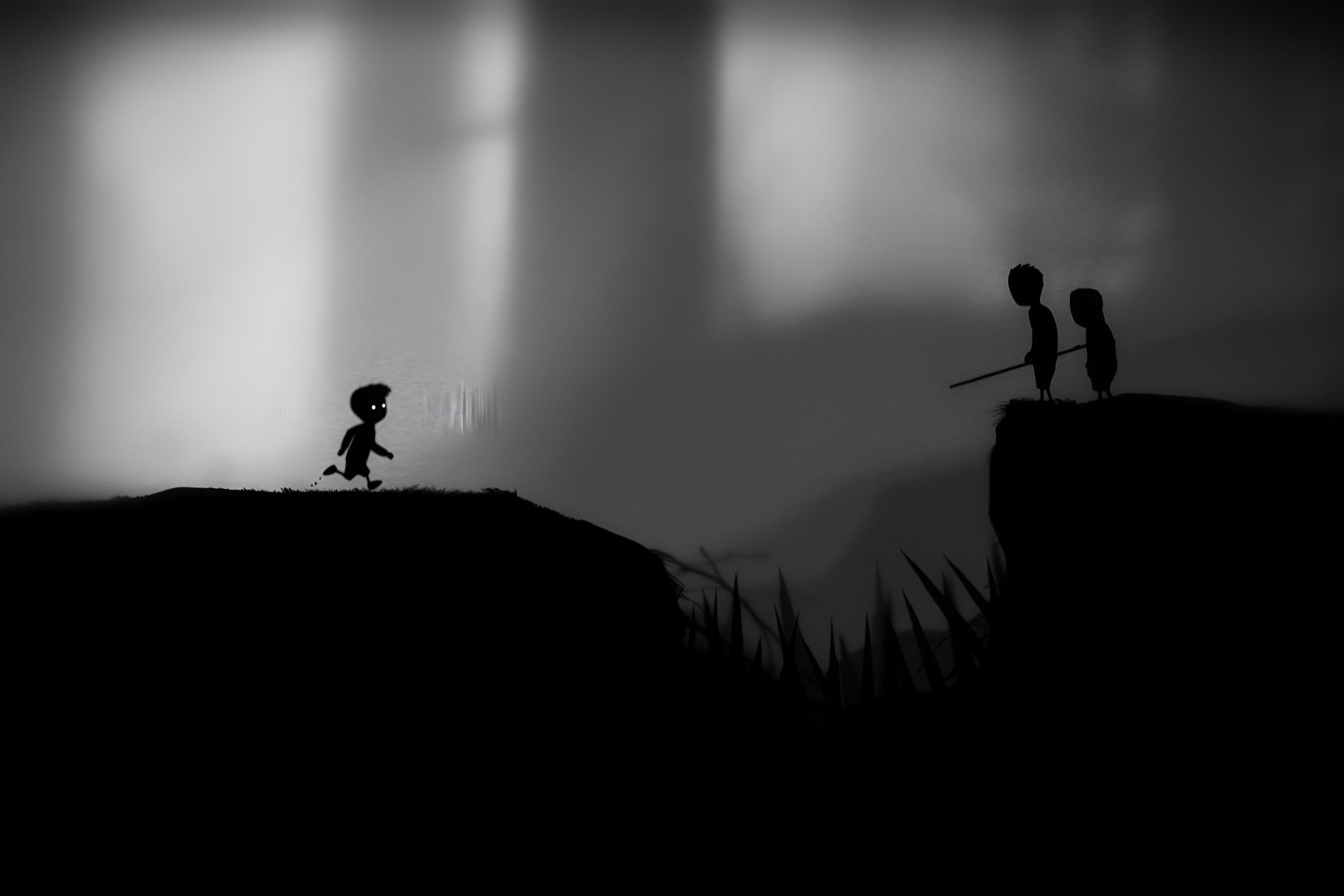 A screenshot from the game Limbo, showing the protagonist running towards two individuals' silhouettes.