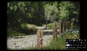 Screenshot from Lushfoil Photography Sim video game of camera taking a photo of wooden fence with metal wire