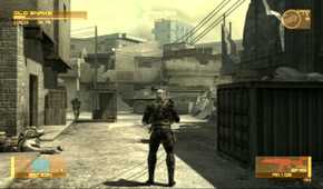 Sceenshot from Metal Gear Solid 4: Guns of the Patriots video game of player character standing in war-torn street with a tank on the road and an armed man to the left.