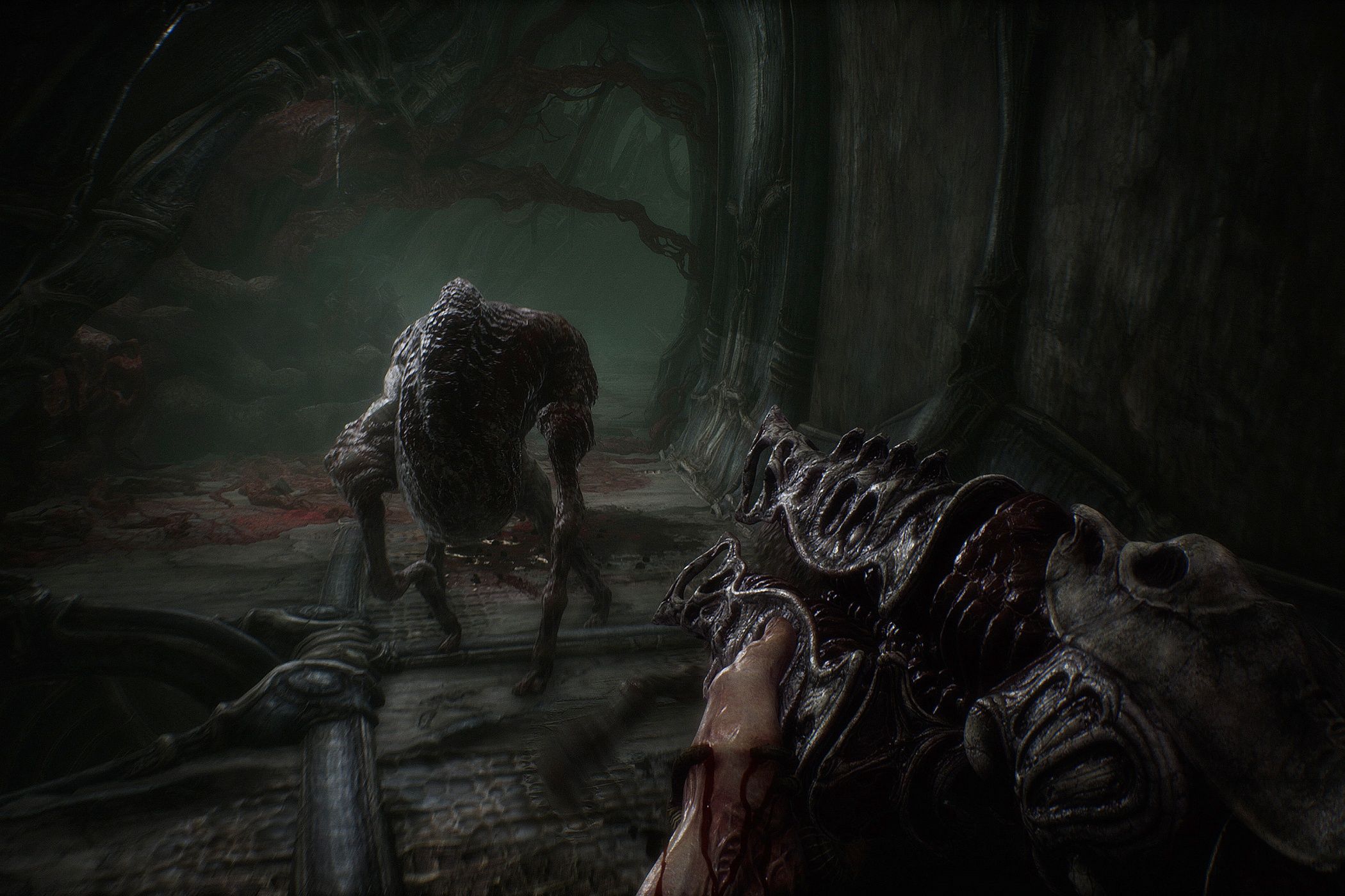 A screenshot from the game Scorn, showcasing the game's gameplay elements, with a gun and a hostile combatant running at the camera on its legs.