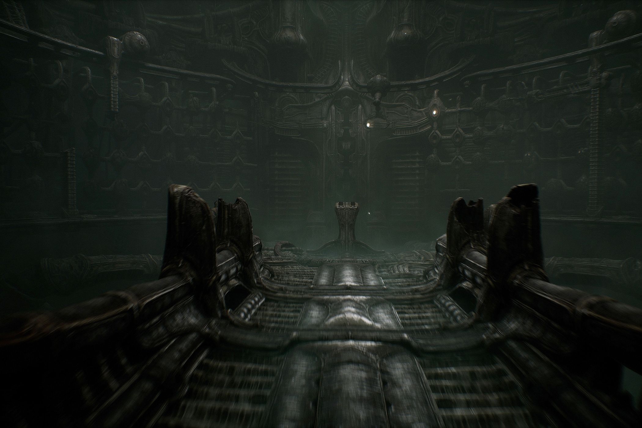 a screenshot from the game Scorn, showing a dark, metallic environment and walkway, with an altar at the end of it.