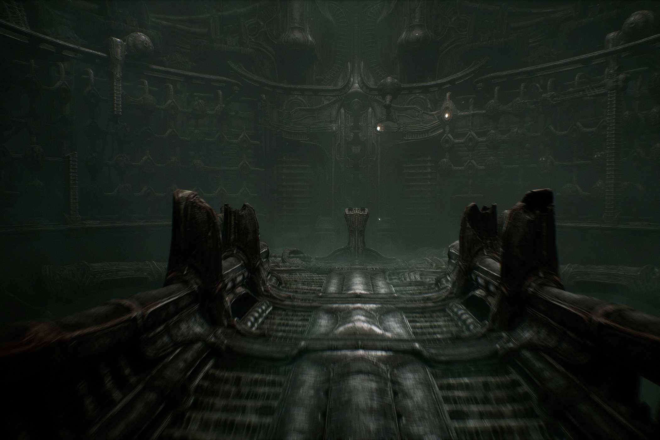 a screenshot from the game Scorn, showing a dark, metallic environment and walkway, with an altar at the end of it.