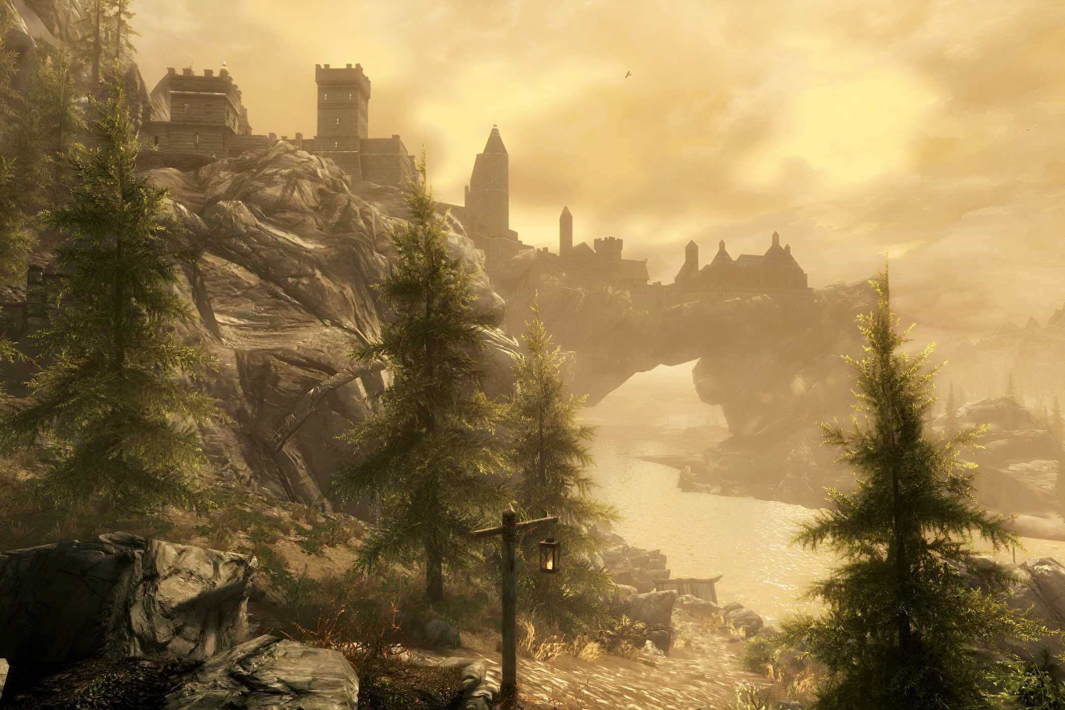 A screenshot from the game The Elder Scrolls V: Skyrim, showing a huge city in the background, with a river running underneath it.
