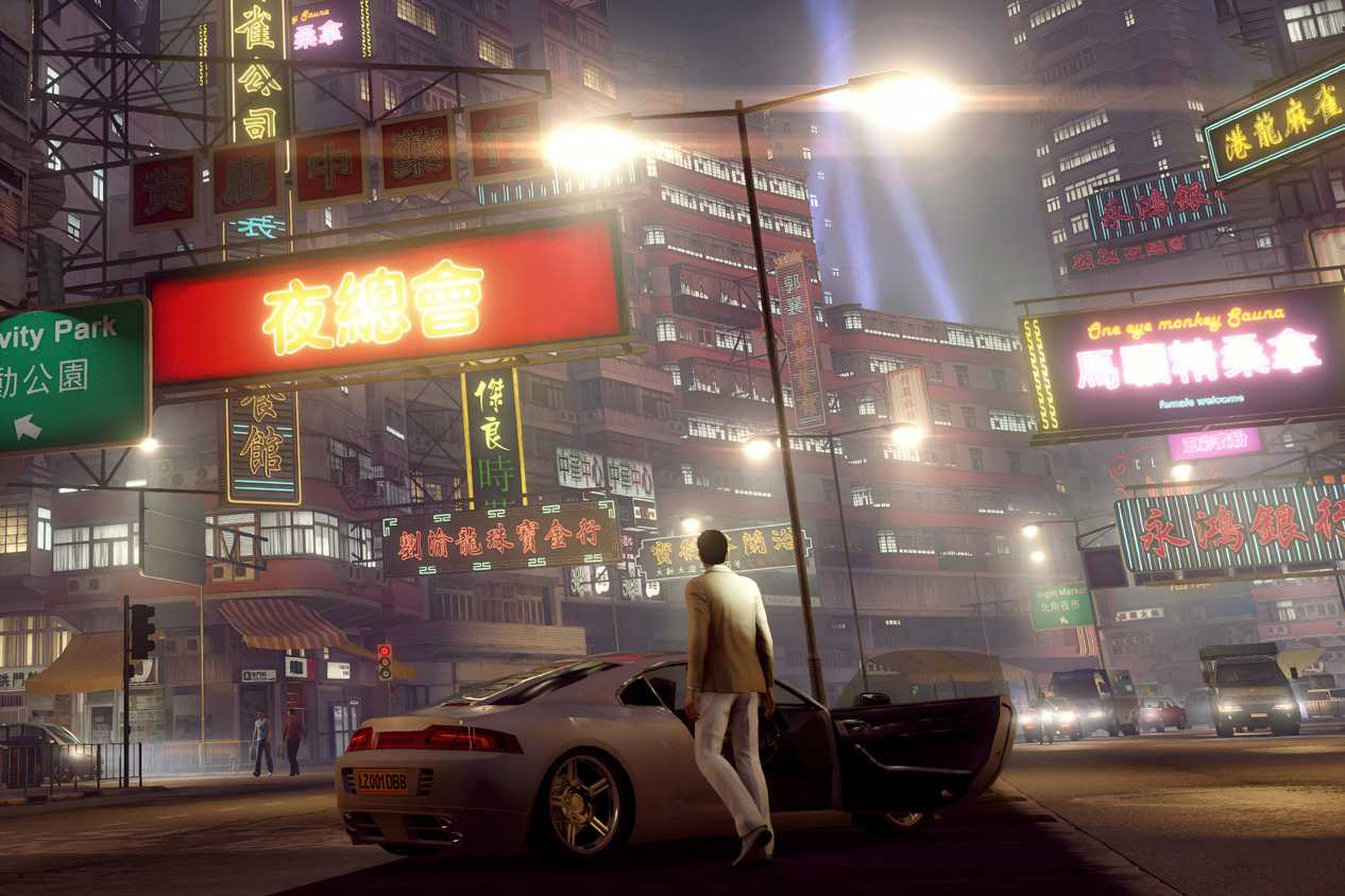 A screenshot from the game Sleeping Dogs, showing a man in a white suit, getting out of a whtie car, and looking at the busy city in front of him.