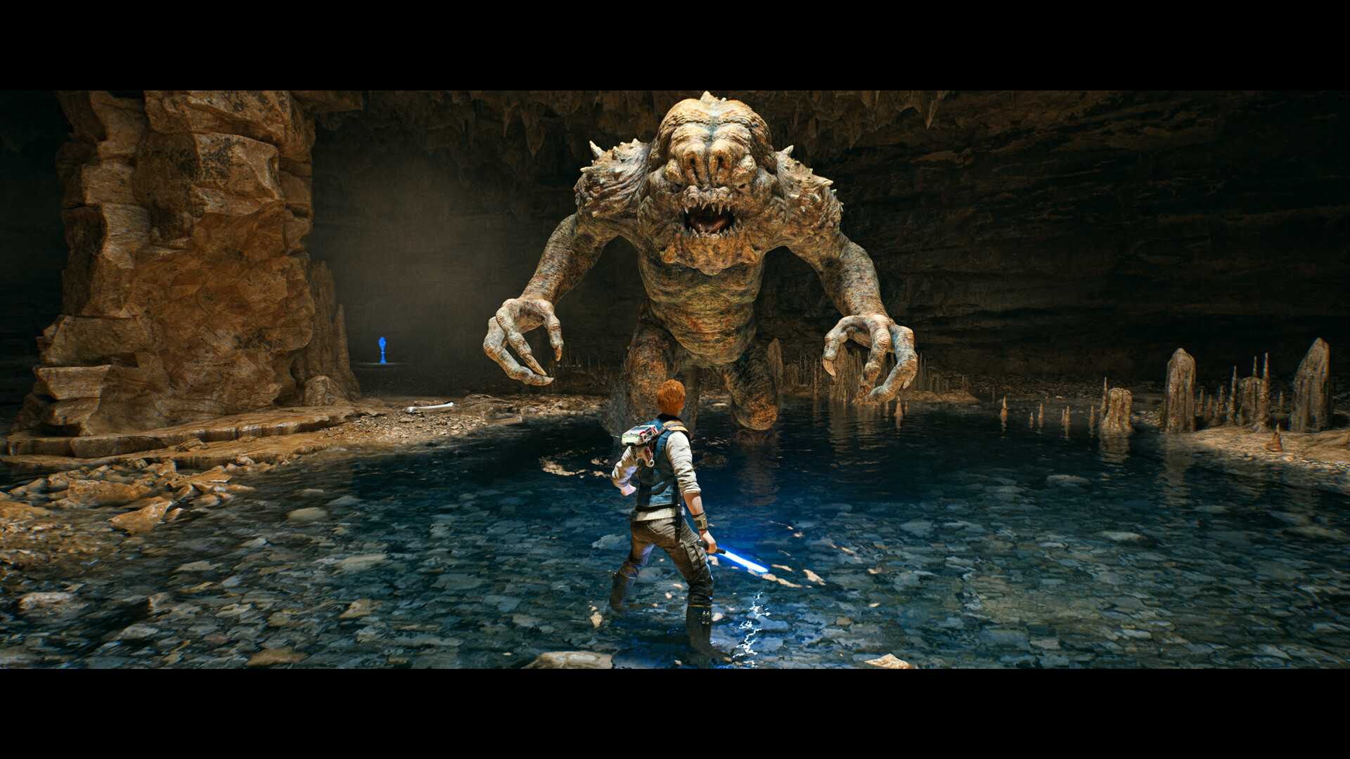 Screenshot from Star Wars: Jedi Survivor video game of main character Kal Cestis fighting Rancor monster in underground pit
