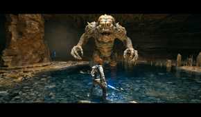 Screenshot from Star Wars: Jedi Survivor video game of main character Kal Cestis fighting Rancor monster in underground pit