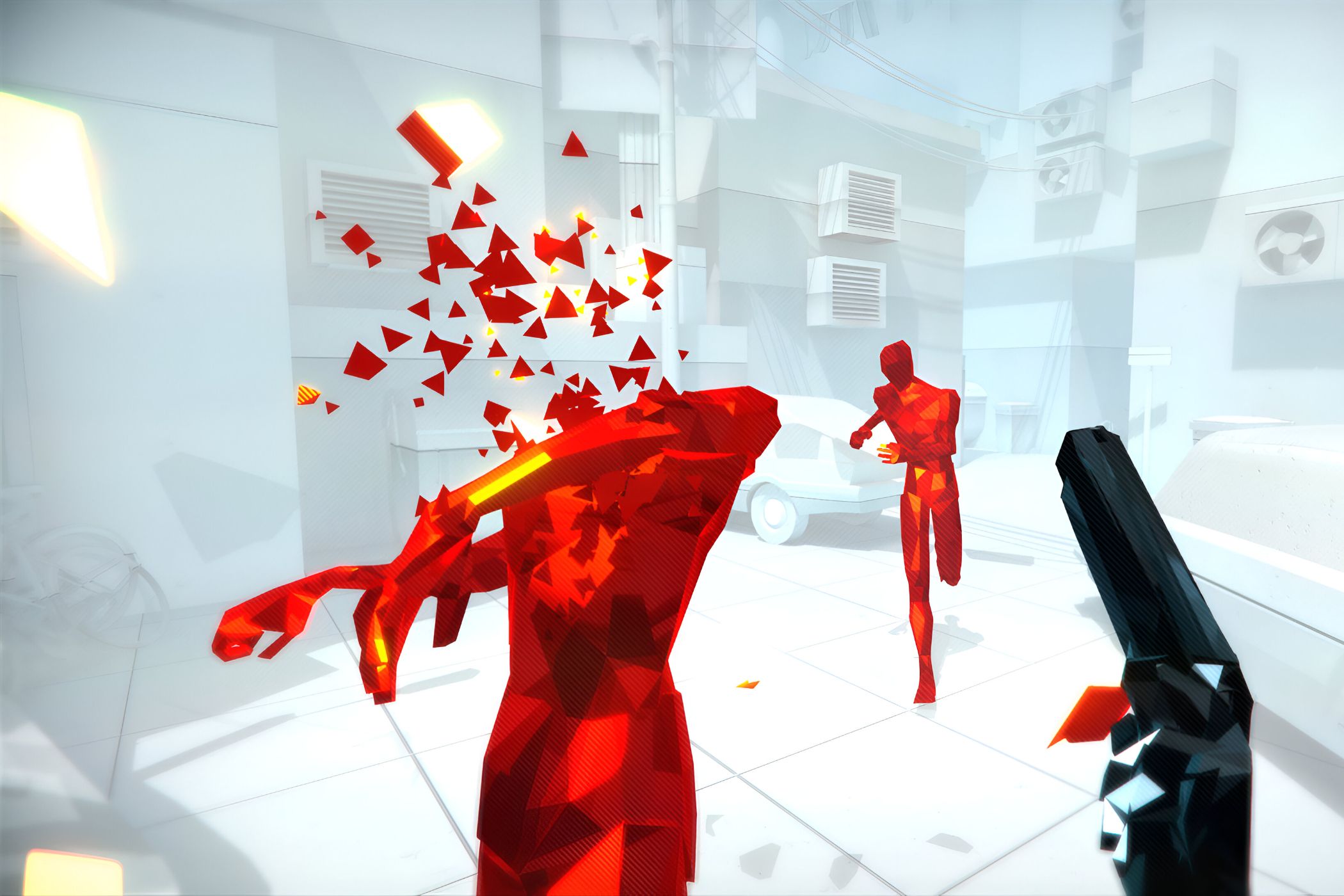 A screenshot from the game Superhot, showing a stark white environment with enemies in red disintegrating as the protagonist wields a black pistol.
