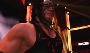 A WWE 2K15 screenshot showing Kane, wearing a red and black vest and a red mask, make his entrance.