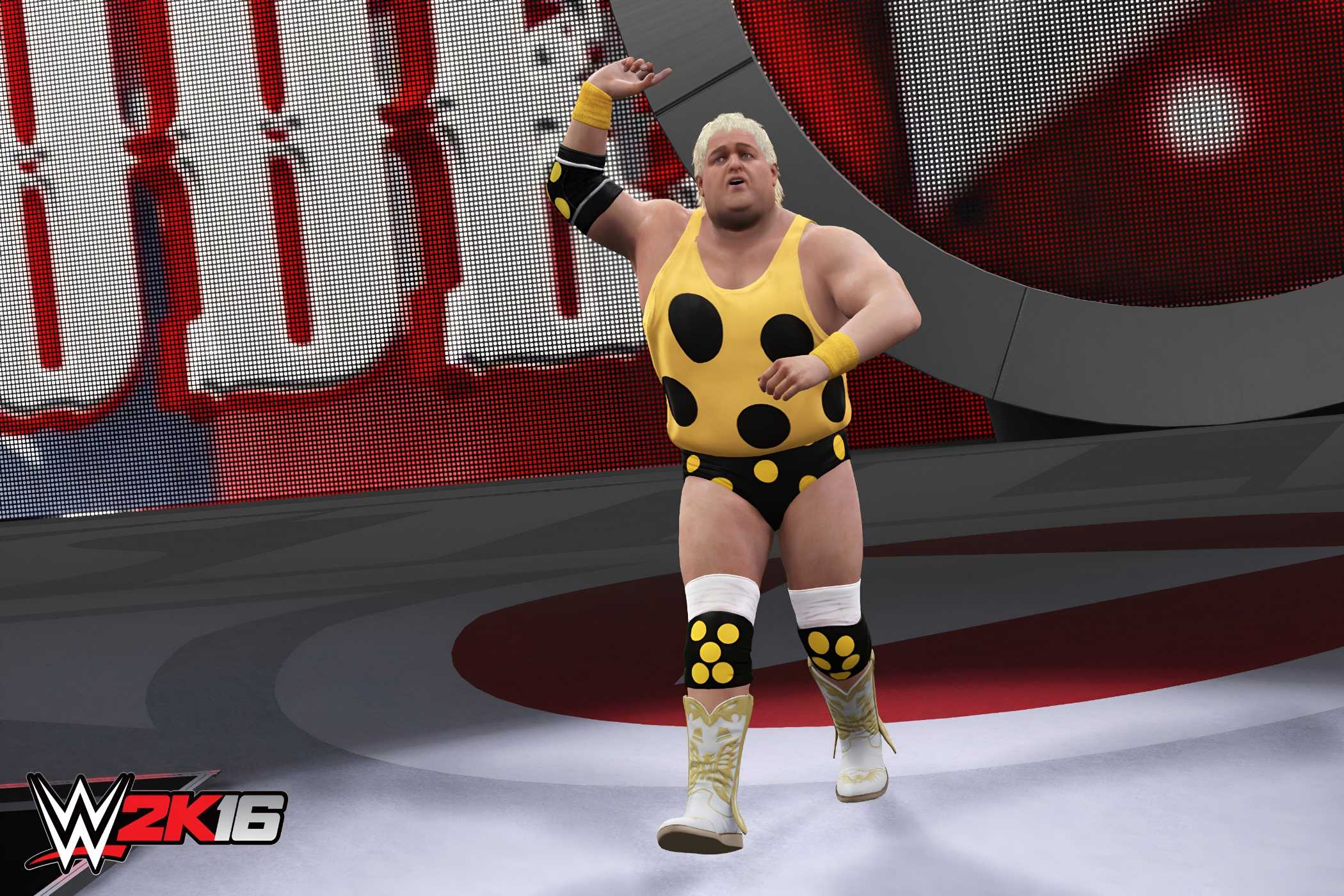 A screenshot from WWE 2K16, showing Dusty Rhodes, a healthy old man with short blonde hair, wearing a polka-dotted yellow outfit, enter the arena while raising one hand in the air.