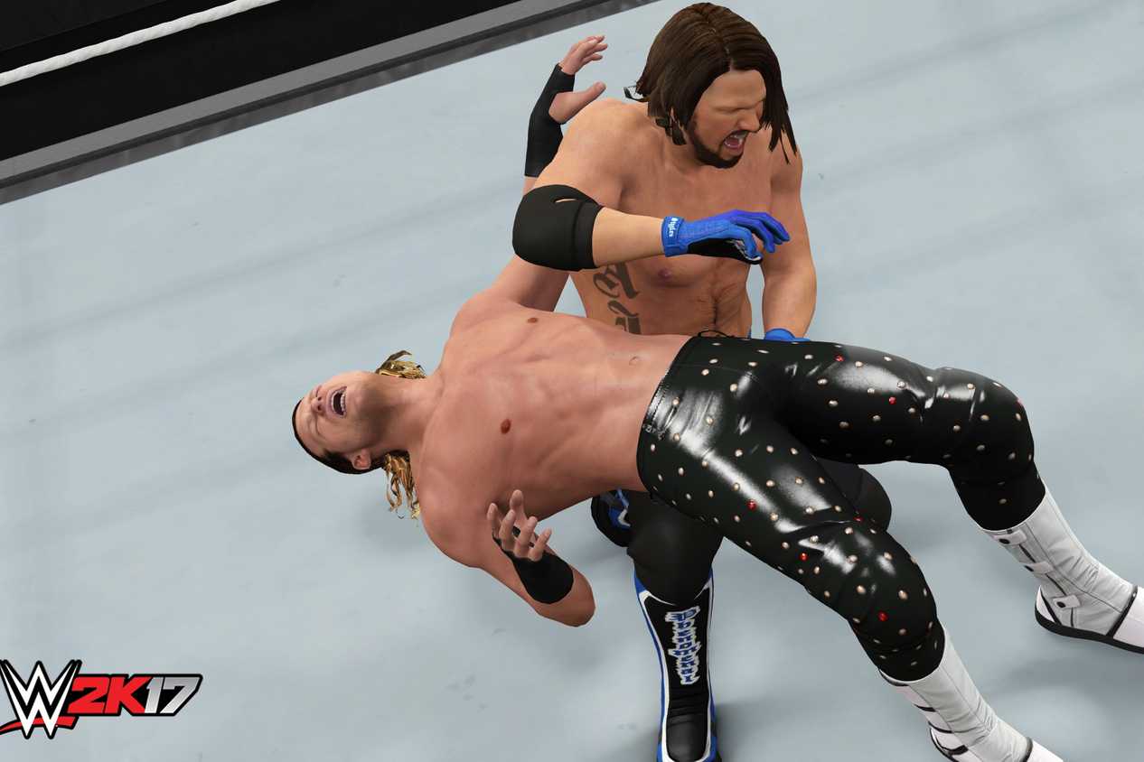 A screenshot from WWE 2K17, showing superstar AJ Styles hit a backbreaker on Dolph Ziggler.