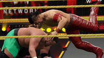 A screenshot from WWE 2K17, showing Shinsuke Nakamura attack a crouched Samoa Joe wearing green shorts.