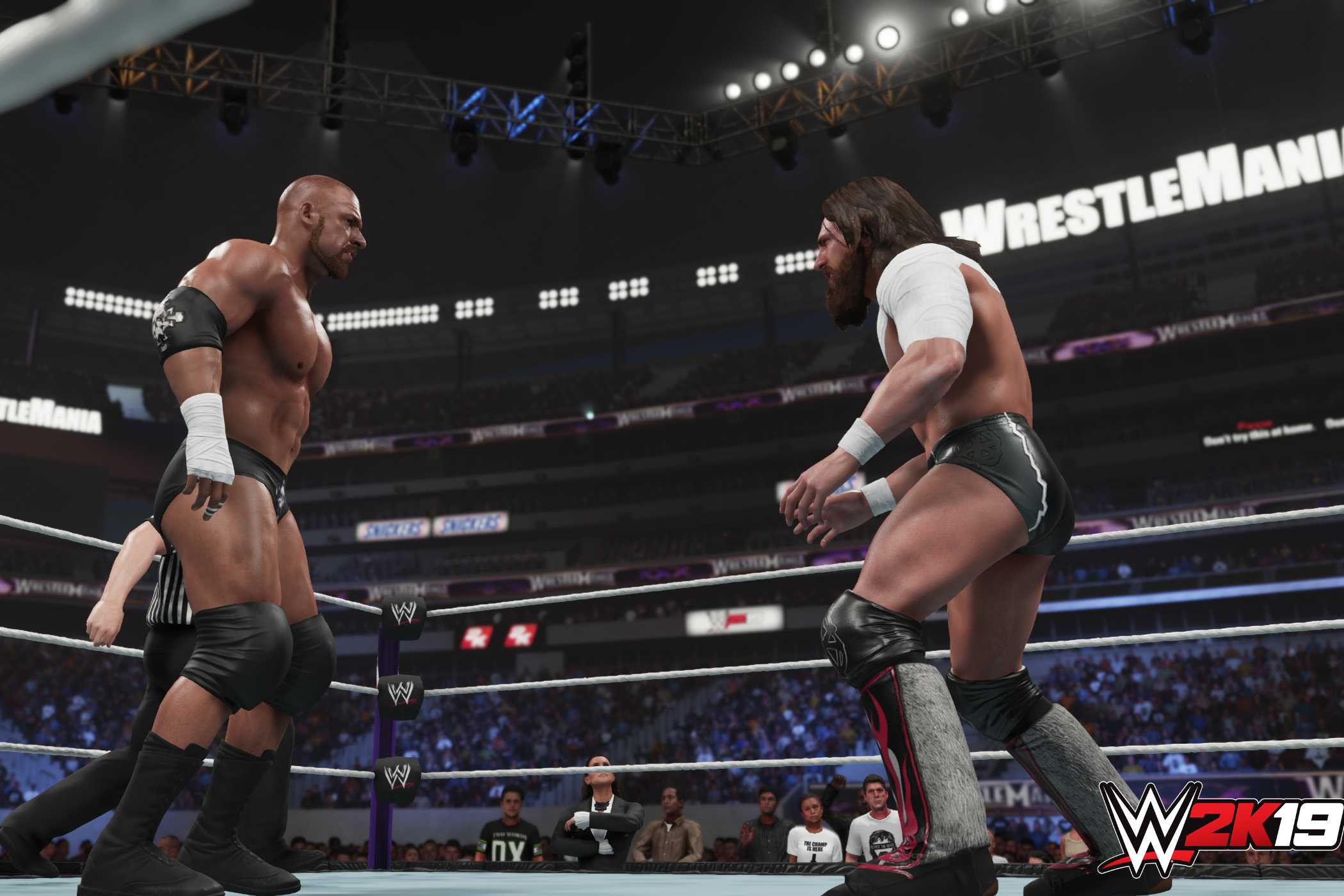 A screenshot from WWE 2K19, showing a bald Triple H face off against a bandaged Daniel Bryan with long hair inside the ring.