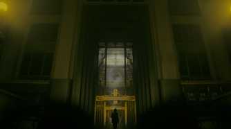 An image from the game "Alan Wake 2", showing a huge building bathed in dim yellow light.