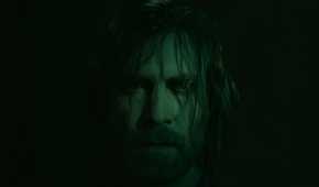 An image from Alan Wake II, showing the protagonist Alan Wake staring into the camera with hair strewn across his face.