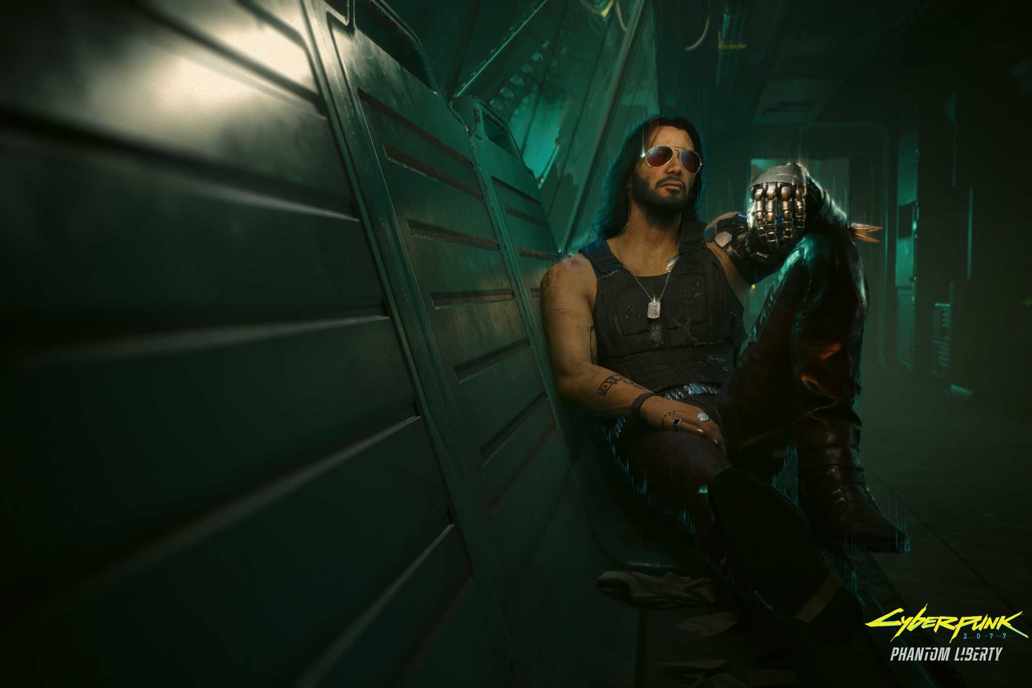 An image from the game "Cyberpunk 2077", showing a man with long hair and sunglasses sitting against a wall in a dimly-lit hallway.