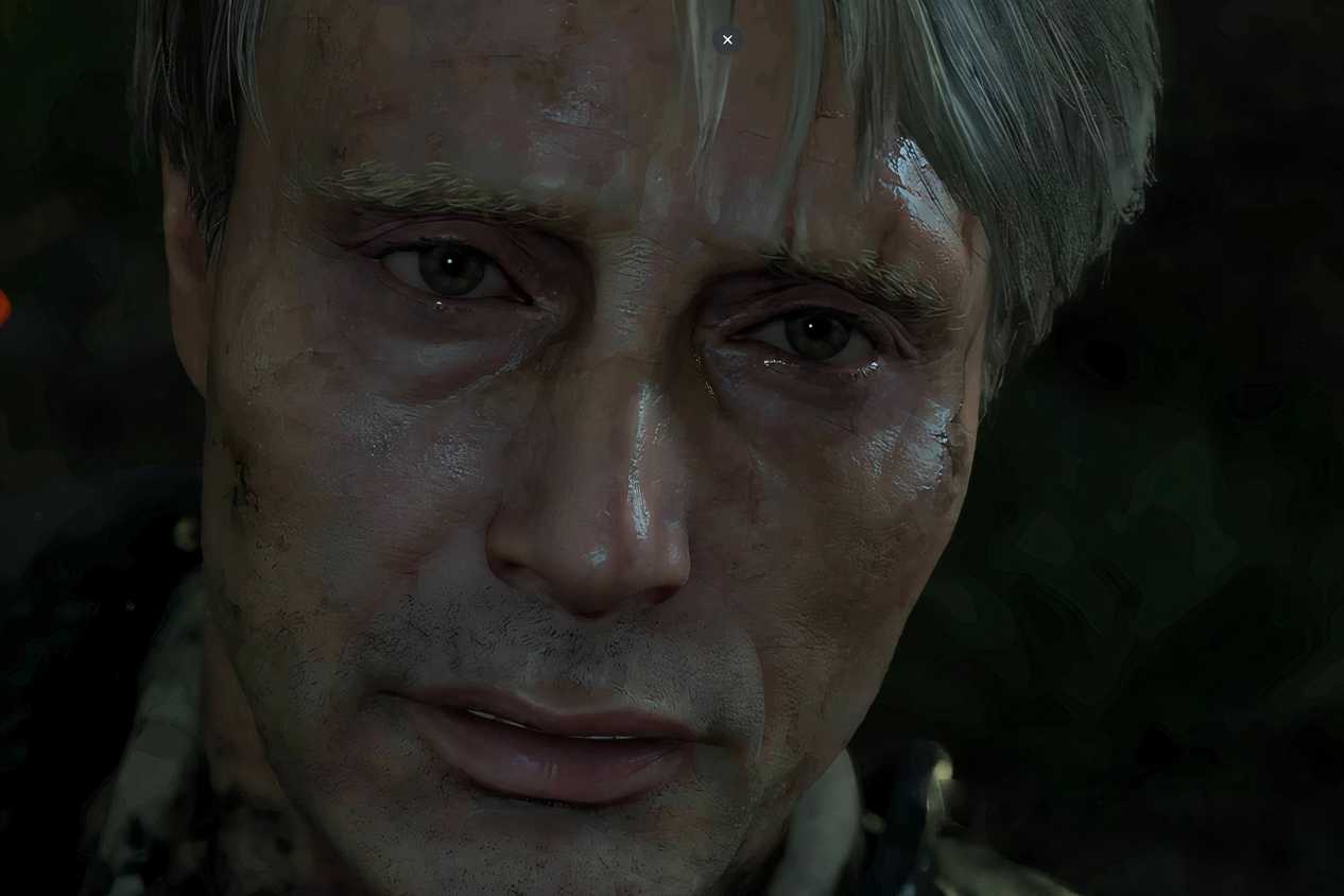 An image from the game "Death Stranding", showing actor Mads Mikkelsen covered in dirt and grime.