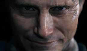 An image from the game "Death Stranding", showing a man staring into the camera with a smile on their face.