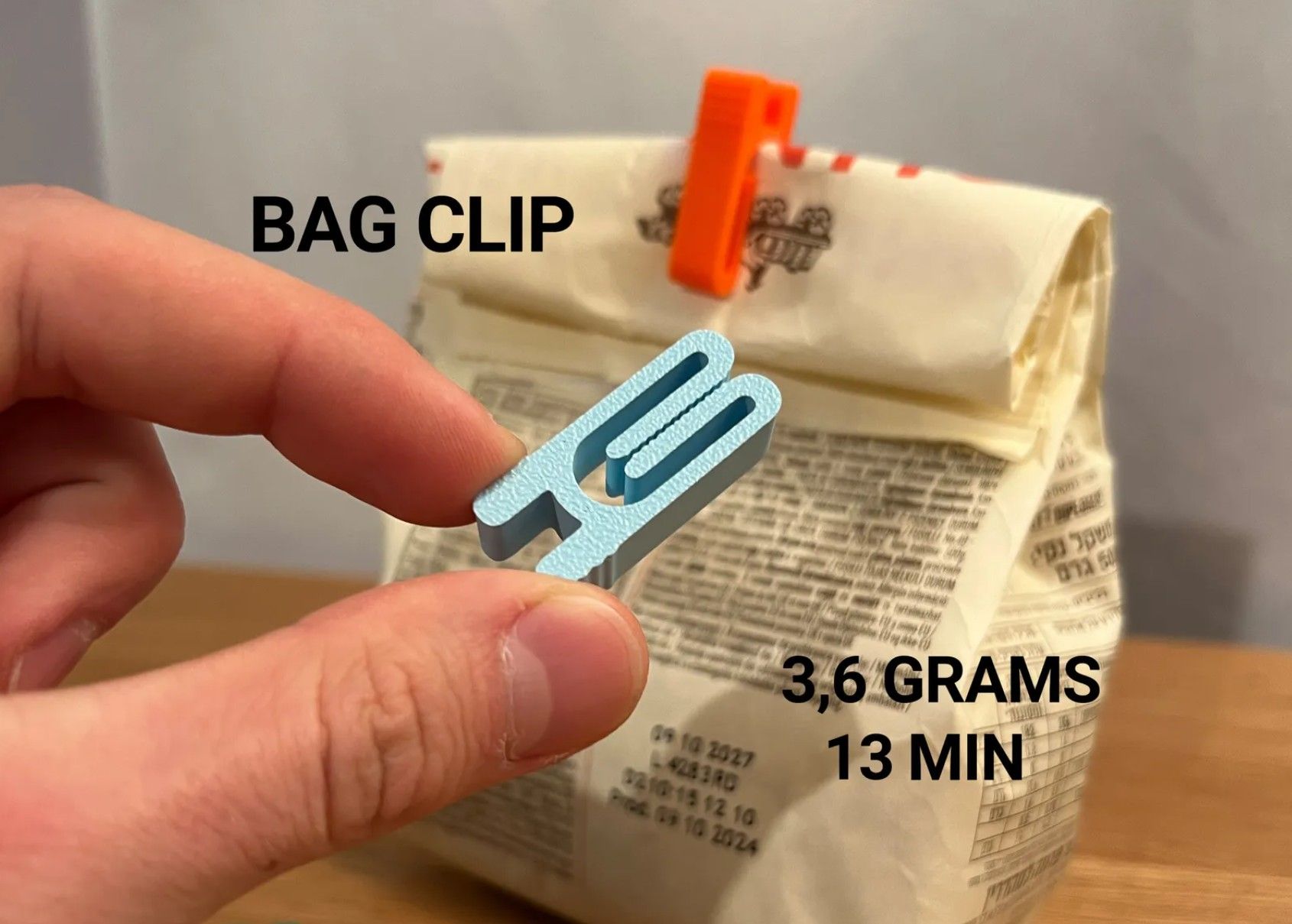 A hand holding a bag clip and another attached to the bag