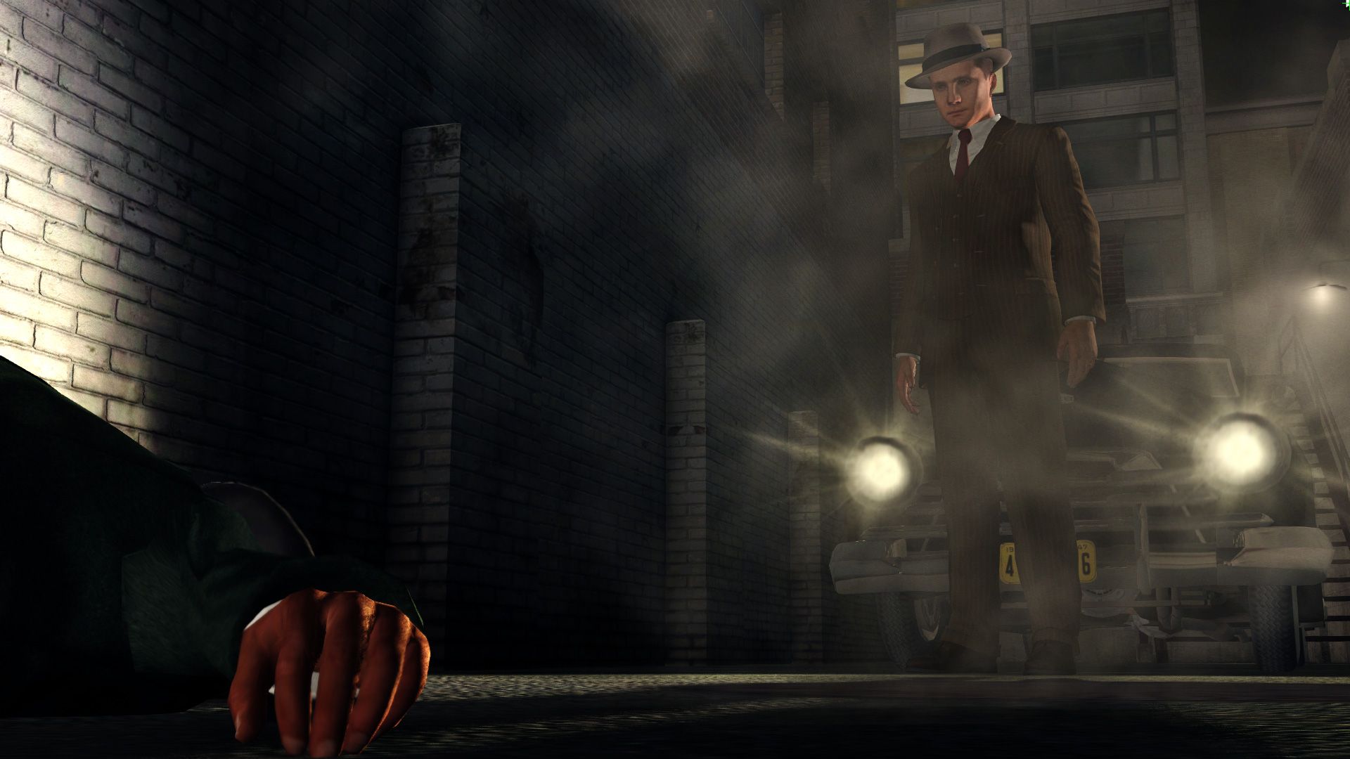 Screenshot from LA Noire video game of man staring at a body on the ground with a car behind him flashing its headlights