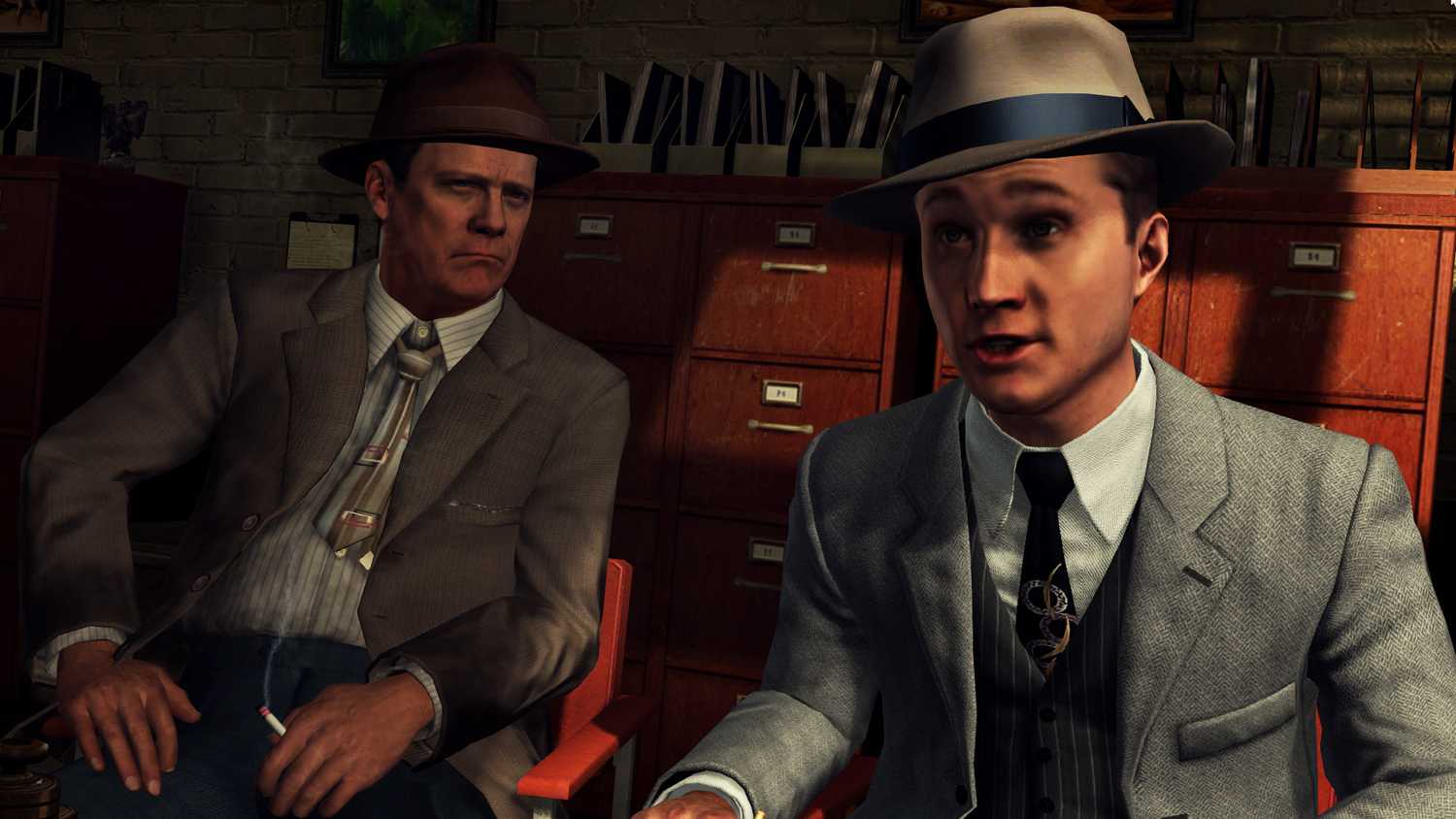 Screenshot from LA Noire video game of two men in 1940's US attire in office room talking.