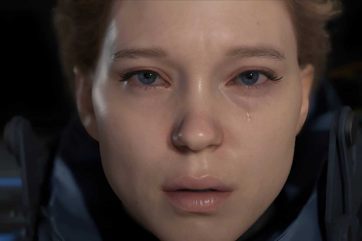 An image from the game "Death Stranding", showing actress Lea Seydoux as Fragile, staring into the camera as a teardrop rolls down her face.