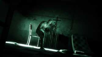 A screenshot from the game Outlast, showing a deranged peson in a nighvision filter.