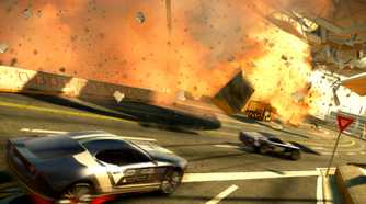An image from the game "Split Second", showing cars race alongside a stadium while it blows apart and goes up in flames.