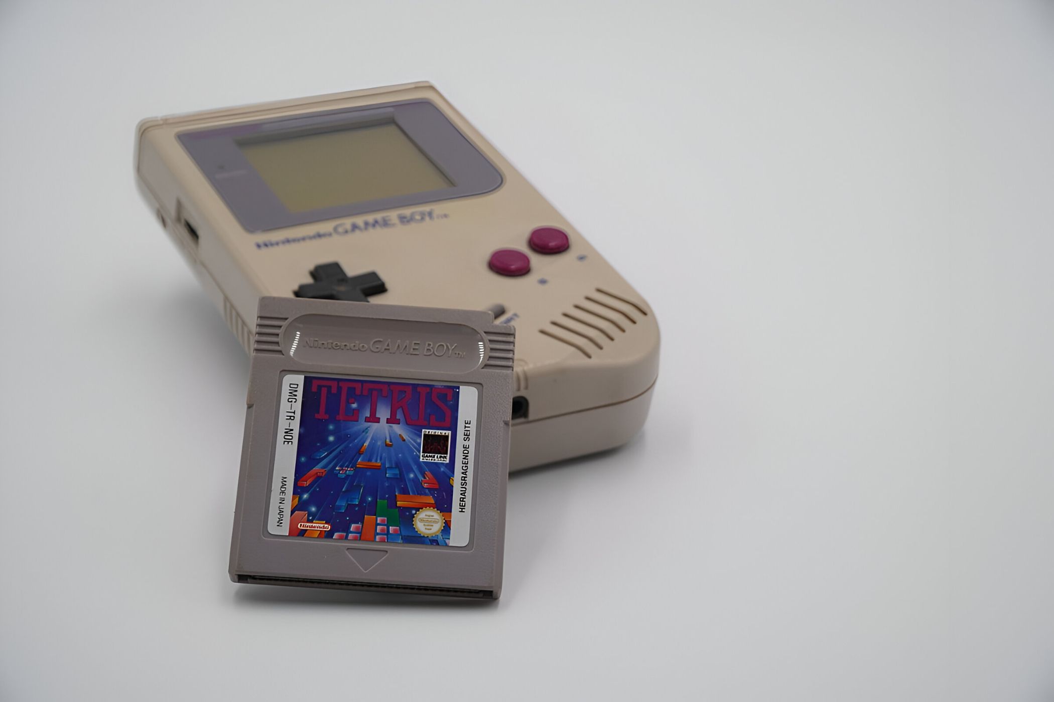 A Game Boy with a Tetris cartridge resting against it.