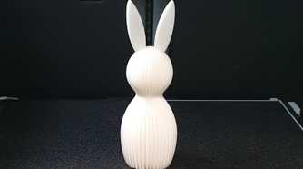 A white easter bunny on a 3D printer bed